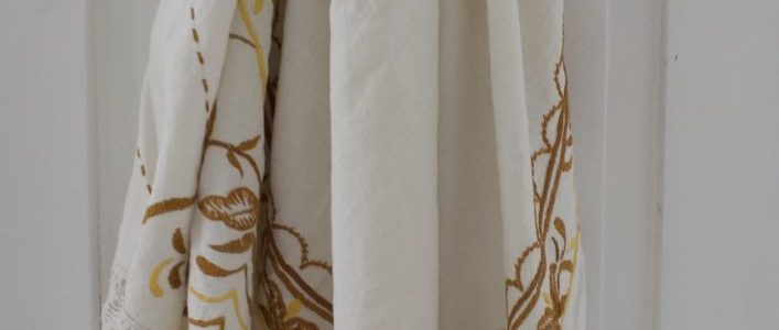 Valkoinen pöytäliina kuviolla ja pitsi reunuksilla